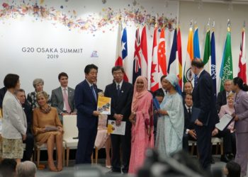 ADB President Mr. Takehiko Nakao (right) hands to Japan Prime Minister Mr. Shinzo Abe a report on an ADB Sri Lanka women’s entrepreneurship project during the Osaka G20 Summit.