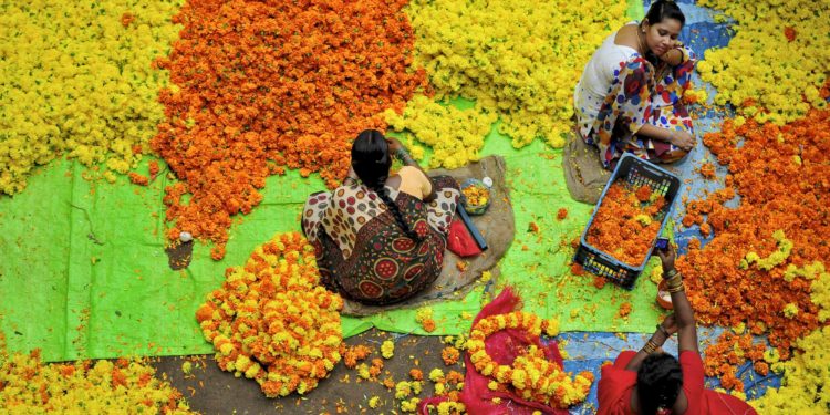 Vendors sit at a flower market in the southern Indian city of Bangalore August 7, 2014. REUTERS/Abhishek N. Chinnappa (INDIA - Tags: SOCIETY) | Nur für redaktionelle Verwendung.