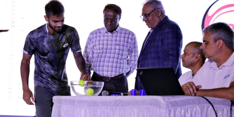 Sumit Nagal (left) picks up a ball during the draw ceremony at the KSLTA on Friday. Also seen are Mr. M. Lakshminarayana, IAS, Vice President, KSLTA and Advisor to the Honorable Chief Minister, Govt. of Karnataka, Tournament Director Sunil Yajaman and ATP Supervisor Andrey Kornilov (extreme right).