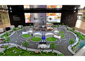 Hyundai Motor employees view a miniature model of smart mobility solutions, including UAM, PBV and Hub, for a dynamic human-centered future city concept, displayed in the first-floor lobby of its headquarters.