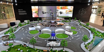 Hyundai Motor employees view a miniature model of smart mobility solutions, including UAM, PBV and Hub, for a dynamic human-centered future city concept, displayed in the first-floor lobby of its headquarters.
