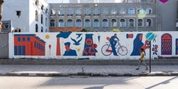 A passer-by admires the mural on PB Marg in Worli which is a tribute to the transformation of textile mills in Mumbai and was created as a part of the Birla Estates’ public art initiative- Mumbai Rising