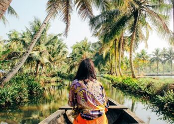 A young woman kayaks through the backwaters of Monroe Island in Kollam District, Kerala, South India.