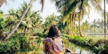 A young woman kayaks through the backwaters of Monroe Island in Kollam District, Kerala, South India.